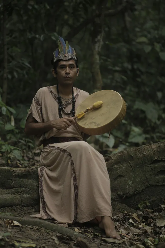 Maestro Qinty with a ceremonial drum in the forest